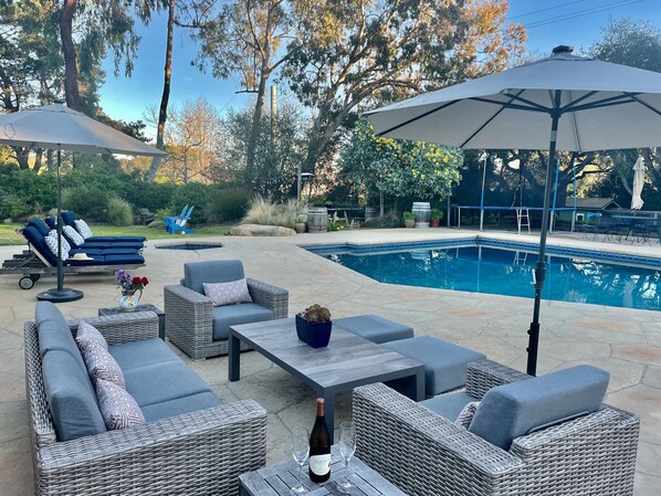 The backyard has many spots to relax poolside. 