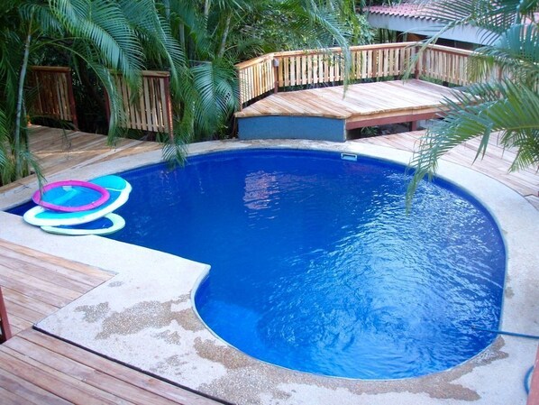 Teak decking with a deep pool in a tropical jungle setting.