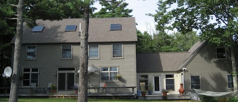 Back of the home with sits on open meadow 