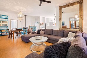 A cosy and inviting space to relax, the stylish living area features plush seating, a flat-screen TV, and a wood heater for warmth on cooler nights.