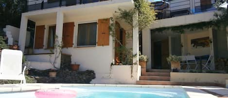 Villa showing poolside bedroom and shaded dining area.