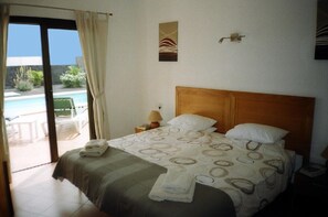 Main bedroom patio doors overlooking  the pool. Full bathroom en suite.