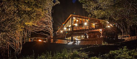 A beautiful night shot of the rental house lit up & fire pit blazing!