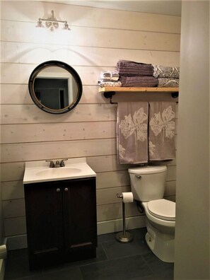 Newly renovated bathroom with extra towels, shower, sink, etc.