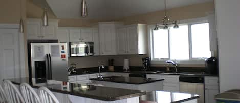 Spacious kitchen with serving breakfast bar.