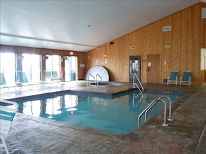 Indoor pool with a Jacuzzi in the far corner. Sauna is also in the same location