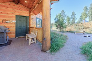 Our cabin's front brick patio offers seating, a propane grill and private fire pit 