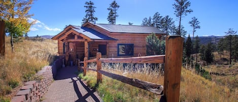 Step into serenity at the front entry of our cabin, where a brick walkway welcomes you to your mountain retreat. Take in the stunning mountain views as you approach the cabin. 