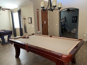 Front room with pool table and foosball table.