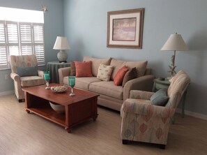 Living room seating area with flat screen TV and laminate bamboo flooring.