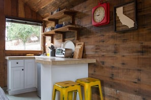 Kitchenette with hot plate, toaster oven, kettle, small fridge, small sink