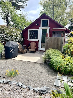 Private backyard space with outdoor shower, gas grill, and seating