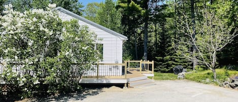 Front view of the house in May, lilac tree in bloom.  Parking to the right.