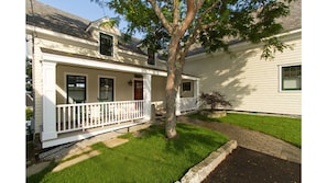 Covered porch with rocking chairs to watch the world go by on Bay View.