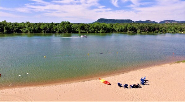 Private swim area protected by roped buoys features kayaks and beach chairs.