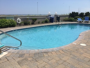 The pool is  next to the beach.