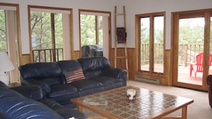 Large family room with wrap around deck/windows. View galore!