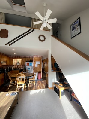 view of stairs up into open second floor loft from living room