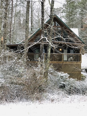 View of front of cabin in serene snow overlooking the woods.
Taken January 2019
