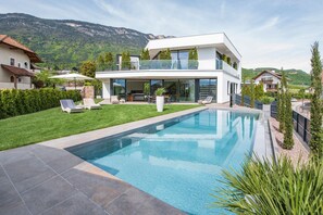 Ein Ferienhaus mit moderner Architektur, großem Garten und Outdoor Pool