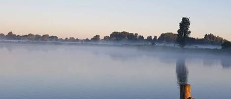 Morgens am See bei Sonnenaufgang, wenn der Nebel steigt, nur 20 Meter vom Chalet