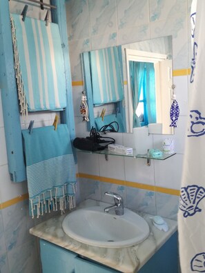 A bright, nicely equipped bathroom, embellished with the colors of the sea