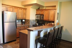 Fully equipped kitchen with counter seating for 4 and a heated slate floor.