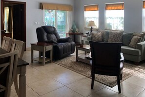 Spacious living room with views of the pool and ocean