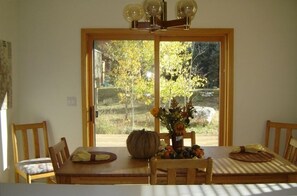 View from kitchen looking over bar counter into dining room and deck beyond.