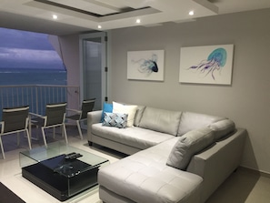 Modern living room with TV and open the balcony door and listen to ocean sounds