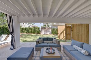 Enjoy outside seating under a covered patio with 
 view of the hot tub and pool.