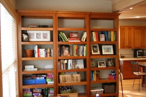 Foyer bookcases with mostly children's pens and pencils and craft paper. 