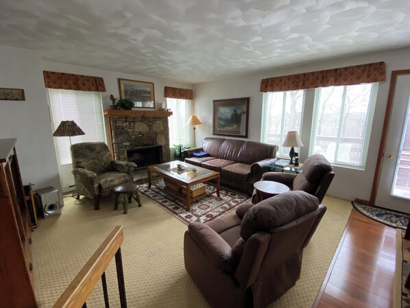 Main Living room with wood burning fireplace and lots of light