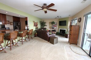 Living area with leather sofa, love seat, ottoman, and counter height bar 