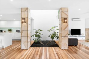 The stunning double-height garden atrium is a focal point of the home, where the verdant touch of an indoor garden brings a sense of tranquility and connection to nature right into the heart of the home