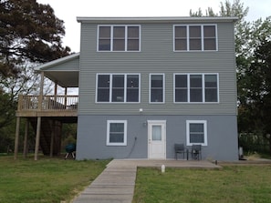 Bayside of house with deck and walkway.