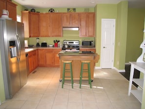 Kitchen with maple cabinetry, stainless appliances and a bamboo island. 