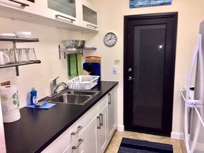 Galley kitchen has large counter and includes coffeemaker, toaster, blender etc.