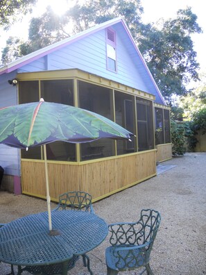 fenced back yard with charcoal grill.