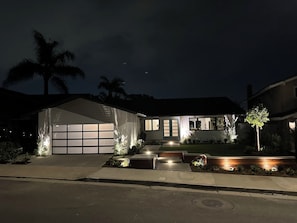 Newly landscaped front yard has landscape lighting.