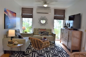 Brightly lit living room with 50" television.