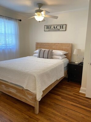 Primary bedroom with queen bed, walk-in closet, and half-bath