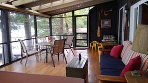 Screened in porch with dining areas overlooking the lake.