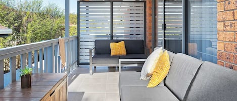 Spacious covered rear patio with outdoor furnishings and bbq