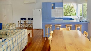 Natural light filled kitchen with breakfast bar and dining area.