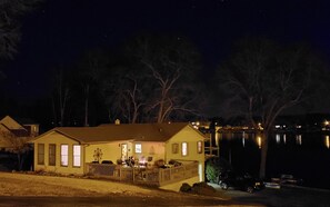 night time view of the house and lake from the street