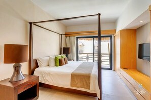 The master bedroom with a stylish king canopy bed, TV & balcony access