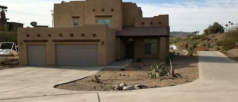 Front of home with large driveway down to boat dock and ramp.