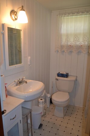 View of our bathroom with a pedastal sink and built in cabinet for storage