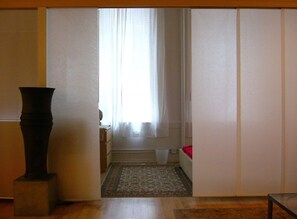 view toward sleeping area w/ queen bed with the fabric dividers open